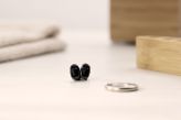ITE hearing aids on a table next to a ring